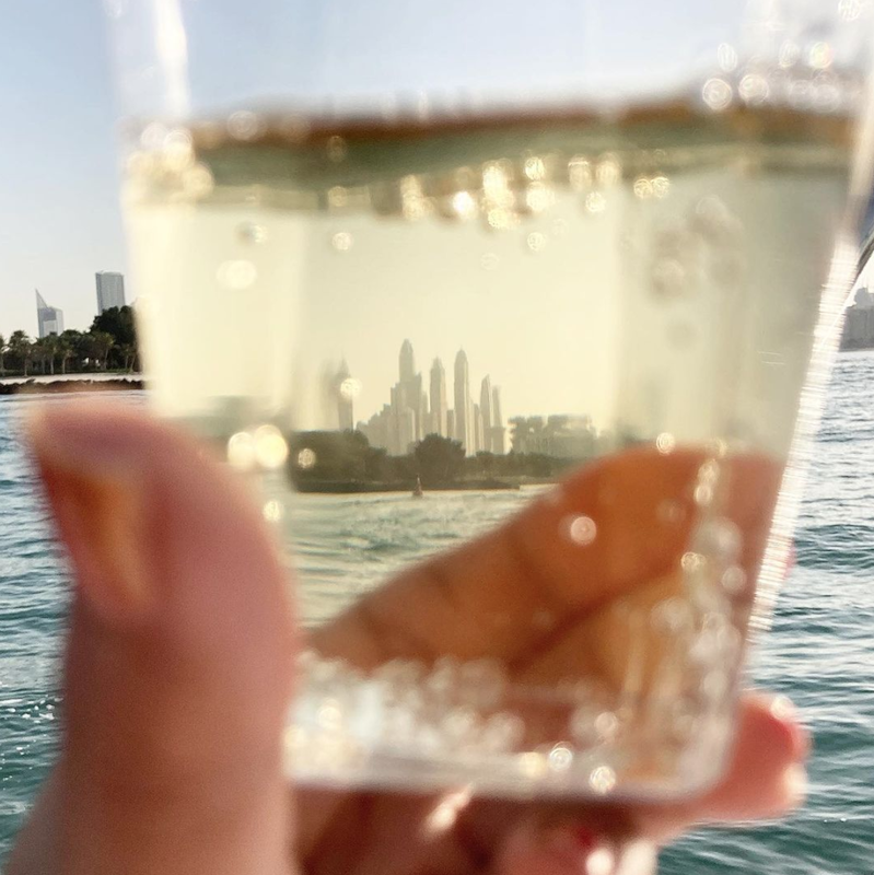 Boat trip view of Dubai Marina, UAE through a glass of champagne